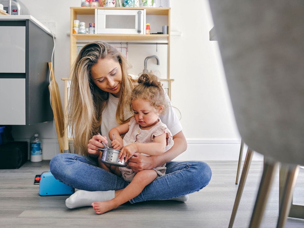 women holding baby on floor