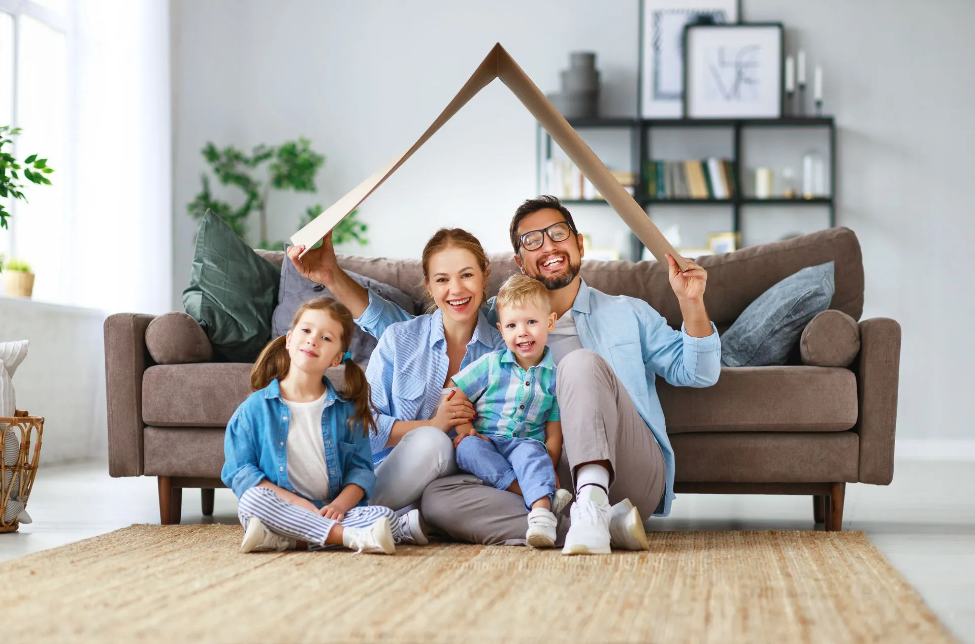 family sitting on floor with carboard roof over heads
